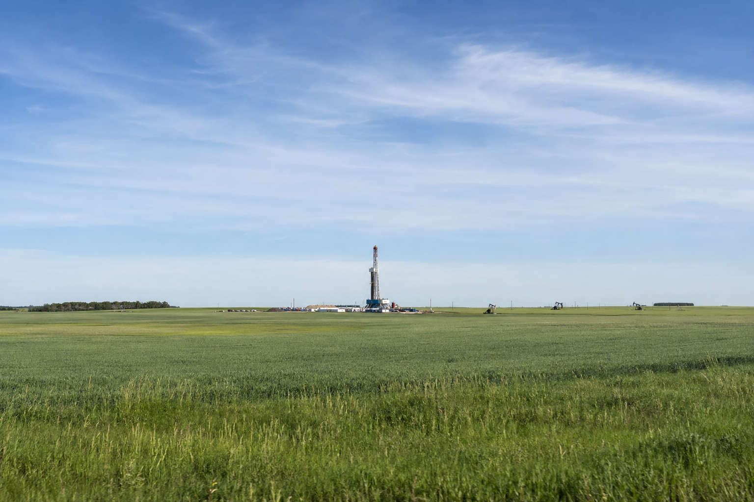 Alberta–Saskatchewan prairie landscape with an oilfield worksite